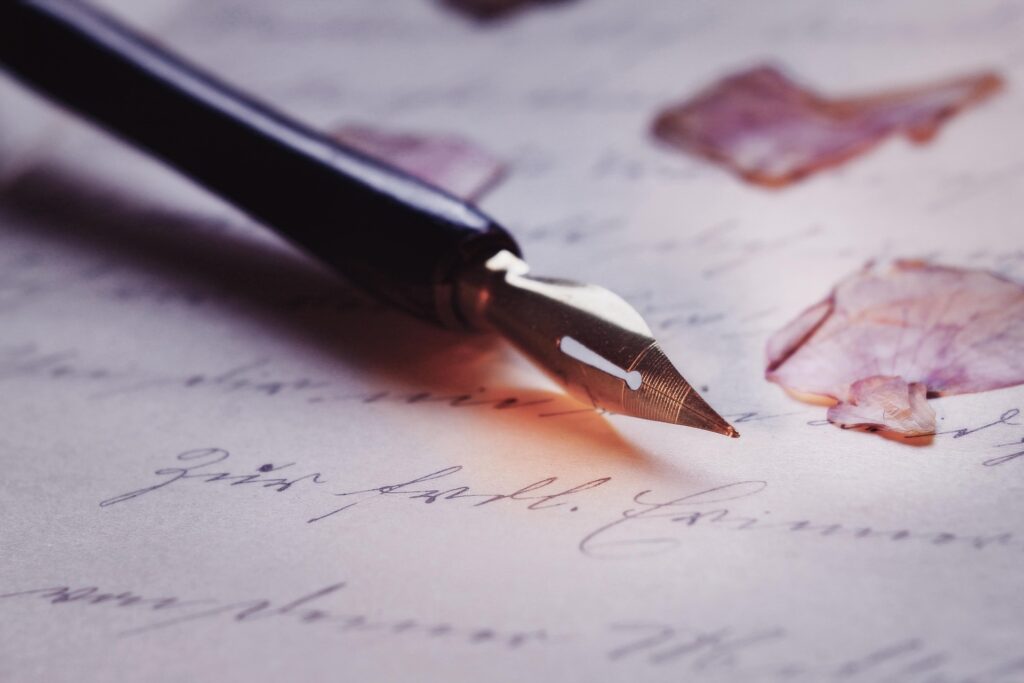 vintage letter with calligraphy pen and flower petals 