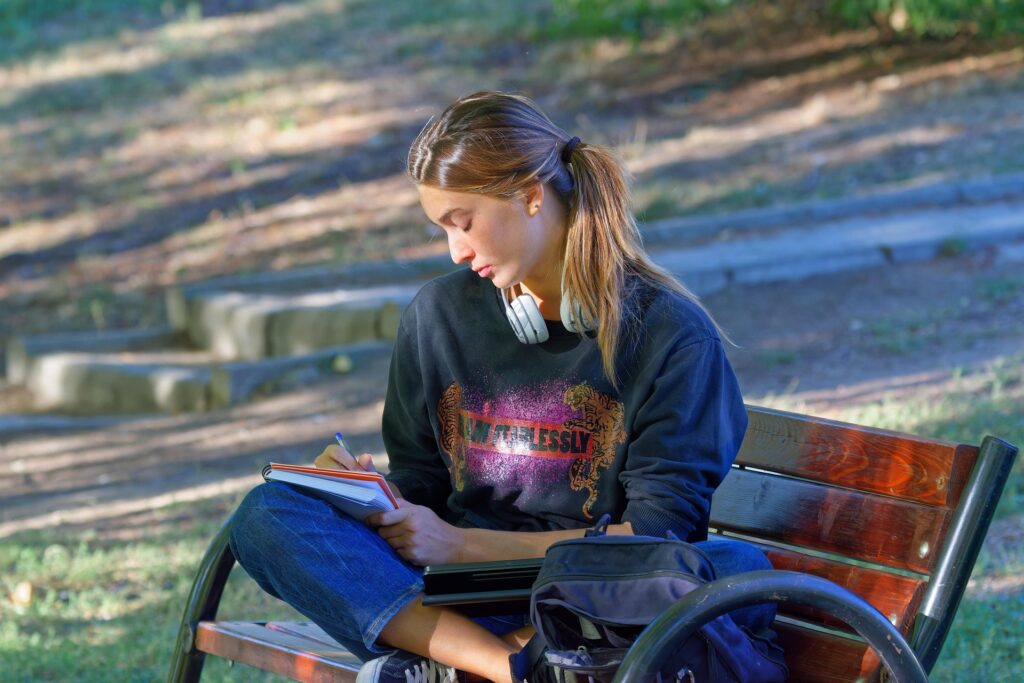 woman sketching peacefully in nature on a bench in park