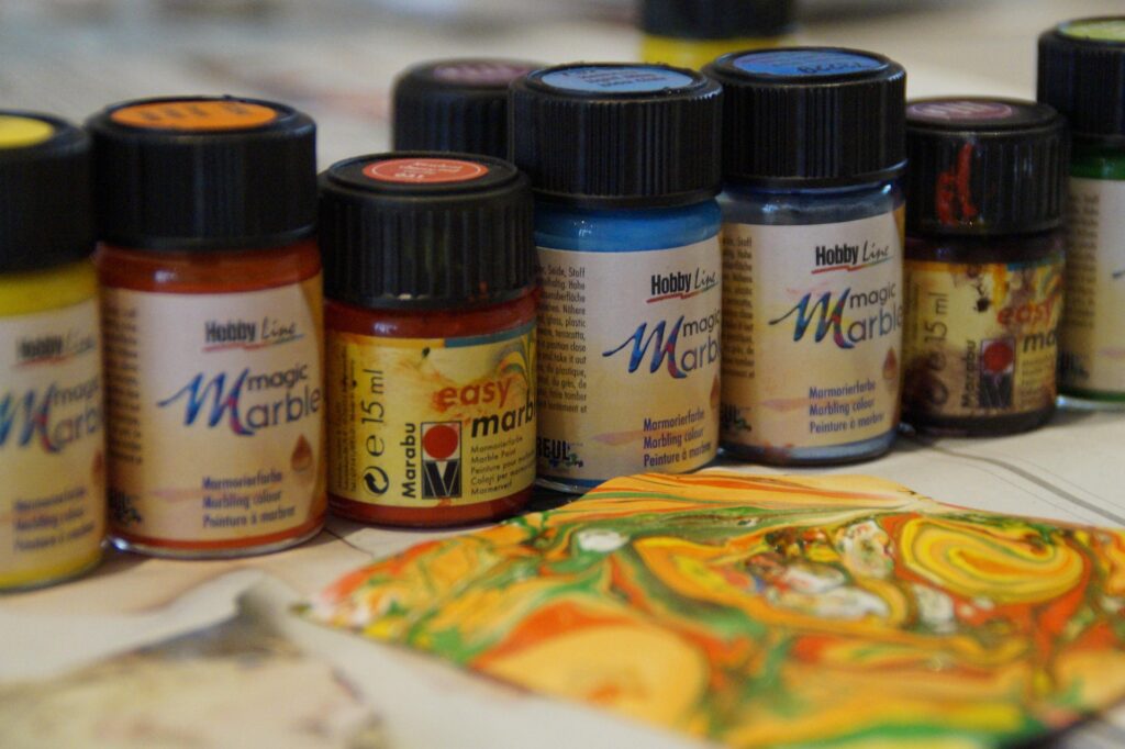 A marbled piece of paper sitting in front of paper marbling paint