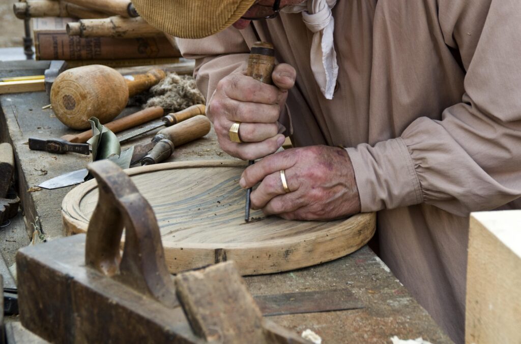 A man carving a wooden tray