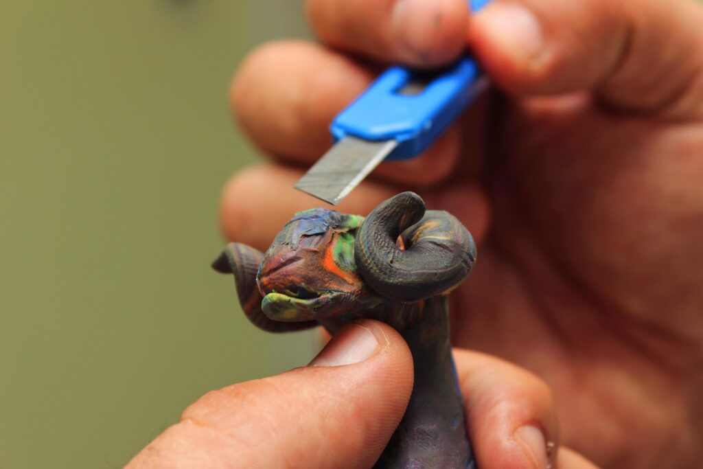 Somebody sculpting a goat out of clay