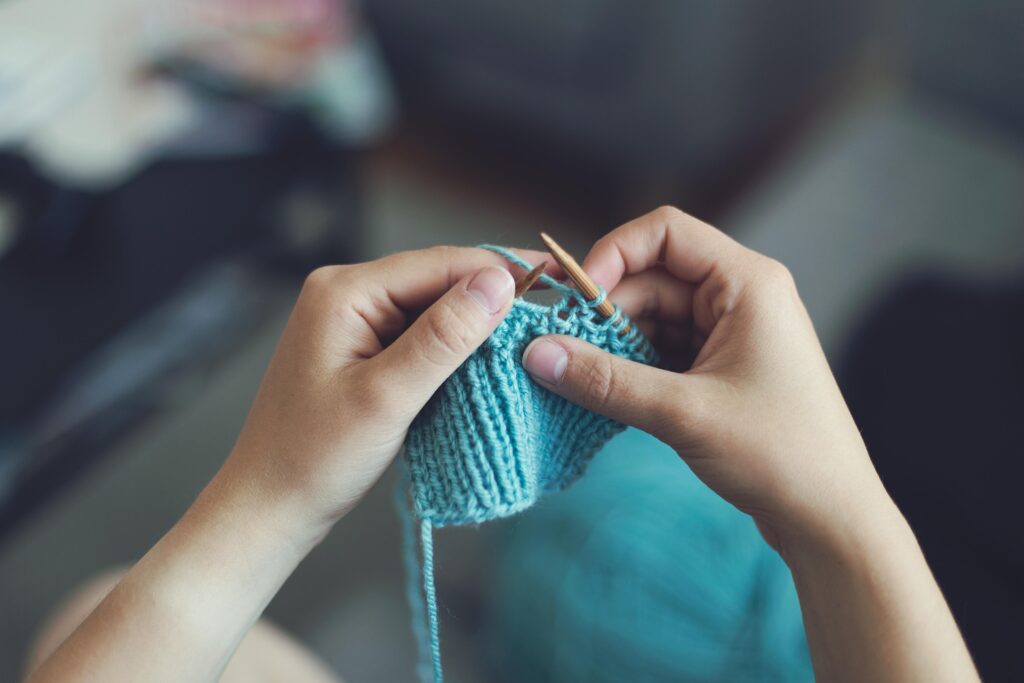 someone knitting with light blue yarn