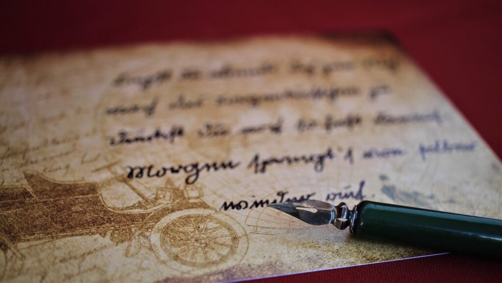 vintage paper with cursive writing and a fountain pen resting on it.